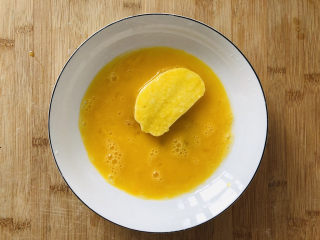 7、烤馒头片,馒头片放入蛋液中两面均匀裹上蛋液。尽量裹的均匀一些。