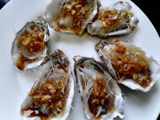 14、蒜蓉粉丝蒸生蚝,将酱用勺子浇在生蚝肉上