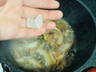 15、紫苏炒田螺,加冰糖,翻炒均匀调料,煮5分钟,让田螺入味;