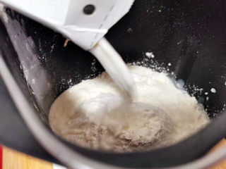 21、梅干菜肉包,把面粉与牛奶混合，放在面包机里揉15分钟左右，两种面粉分开揉