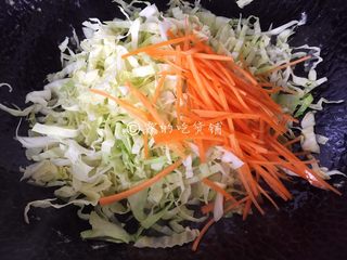 8、家常小炒皇,锅里再倒入少许油,把牛心菜丝和胡萝卜丝倒入翻炒,约1分钟左右。