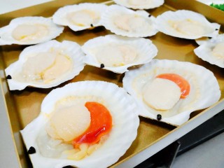 4、芝士焗扇贝,将处理好的扇贝肉放入壳中，排列在烤盘中