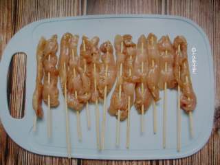 4、甜辣鸡肉串,将鸡肉穿成串摆盘中。