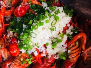 25、蒜蓉小龙虾,最后把剩下的一半蒜蓉和葱叶倒入锅里