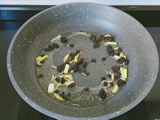 6、干锅香辣蟹,热锅凉油放生姜丝与豆豉炒香。