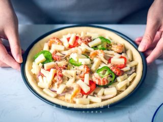 14、麻辣小龙虾披萨,摆上青、红辣椒，将剩下的马苏里拉全部放入，再摆上全部虾尾；