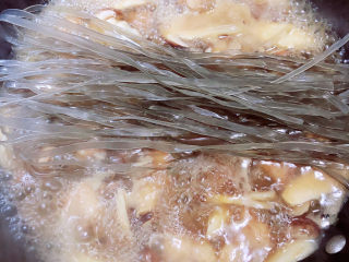 15、小鸡炖蘑菇粉条,放入宽粉，让汤汁将宽粉盖过，盖盖儿继续炖煮。