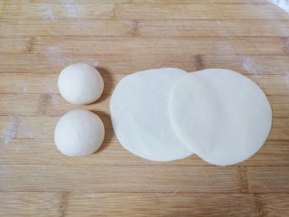 11、胡萝卜韭菜馅包子,将分好的小剂子揉光滚圆压扁，擀成中间稍厚边缘薄的包子皮。