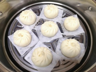 14、胡萝卜韭菜馅包子,蒸锅内放水，篦子上铺上油纸，放上做好的包子生胚，盖上锅盖二次发酵10分钟左右，凉水上锅，上汽后大火蒸10分钟关火，焖5分钟左右出锅。