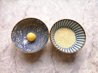 8、南瓜芝麻球,准备两个小碗，一个小碗底放上一点点水，一个小碗里放上熟白芝麻，先把南瓜糯米球放进有水的小碗里沾上水。