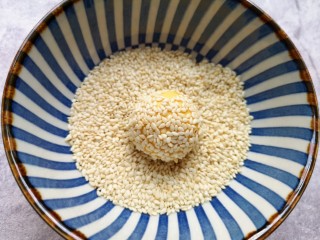 9、南瓜芝麻球,再放进芝麻碗里滚一下粘上白芝麻。