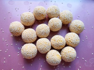 10、南瓜芝麻球,粘上白芝麻的南瓜球再用两个手掌来回搓一下，让芝麻粘的更牢固。