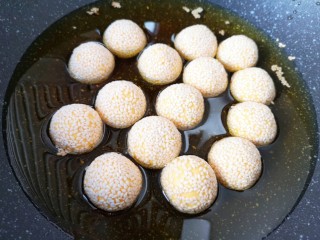 11、南瓜芝麻球,锅内放多一些调和油烧至七成热，下入南瓜芝麻球，中小火炸制。