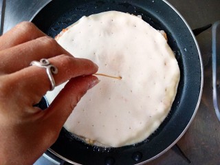 13、鲜虾饼,放入饼坯，并用牙签在虾饼上均匀的戳出气孔，这样煎的时候更容易均匀受热，饼不会鼓大泡。