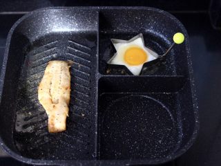 7、开放式鳕鱼鸡蛋三明治,煎锅烧热后，倒入橄榄油烧至六成热时，放入腌制好的鳕鱼，小火开始慢慢煎制，再把鸡蛋也放入煎锅里，我用了模具，没有模具的可以直接煎。