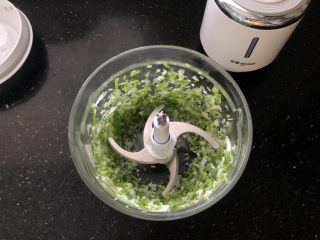 2、营养丰富的胡萝卜香菇猪肉饺子,先把葱段放入绞肉机里打碎。