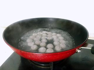 2、醪糟黑芝麻汤圆,汤圆一个个放入锅中，用勺背轻轻推一推使之不粘锅底，这时不用使太大的劲翻动，煮至汤圆浮起后转为小火，往锅中加少许冷水。