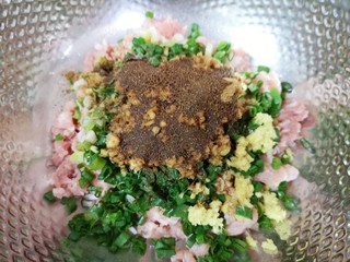 4、水晶蒸饺,准备好肉馅，小葱切碎，生姜剁成姜末，一起放在肉馅上，放上十三香，炒锅内倒适量的食用油烧热，泼在十三香上面，激出香味，搅拌均匀让肉馅静置一会儿。 