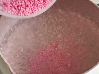 3、缤纷水果西米露,起锅烧水，水开后倒入粉色草莓味西米，中到大火煮15分钟。普通白色的西米也可以