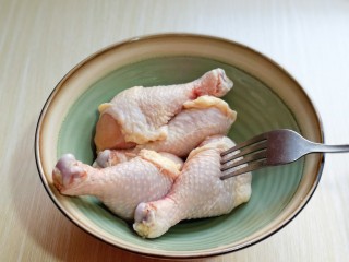 2、好吃不胖~无油低脂零失败的奥尔良面包糠烤鸡腿,首先将鸡腿洗干净,让人器具中,用食品叉鸡腿,差出洞洞,腌制会更入味。