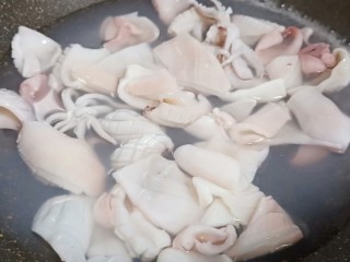 5、3分钟就学会的下酒菜  辣椒炒鱿鱼,锅里加适量的清水、加生姜片3片，水开下鱿鱼入锅焯水。
