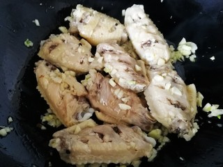 7、蒜香鸡翅,放入鸡翅和蒜末文火炒匀。