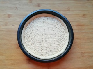 6、百变水果 水果披萨,用叉子扎满小孔,防止饼皮在烤制的过程中中间凸起,做好的饼底静置15-20分钟进行第二次发酵。