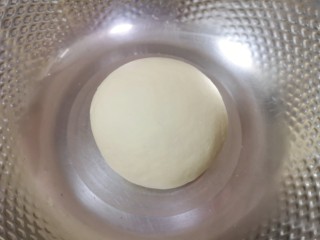2、梅干菜烧饼,加入温水揉成光滑的面团，盖上保鲜膜饧半个小时。 