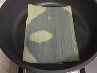 2、烤冷面,平底锅的油加热，放入一片冷面