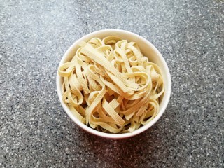 1、骨汤米线,豆腐皮洗干净切成细丝焯熟备用。