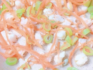 4、杂蔬煎虾仁,4.锅中周围均匀刷上油，然后倒入萝卜丝，小块蚕干豆和已经切成小块的虾仁翻炒至熟。