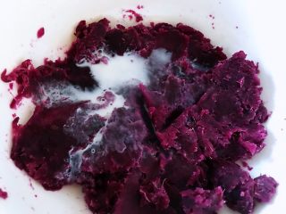 2、饺子皮紫薯饼,加入牛奶，加入白砂糖，用勺子压成泥。加牛奶的意思是因为紫薯太干了，用牛奶稀释一下，一下子不要放太多牛奶。糖加多少可以按照自己的口味来调节，不要放太多了，因为我们人类都对甜食有与生俱来的喜欢，因为孩子喜欢吃就放了一点点，如果说自己吃的话就不需要放了。