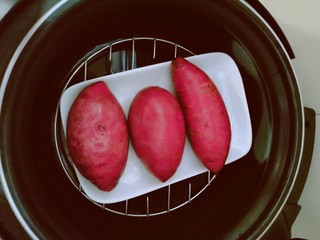 2、紫薯芝麻饼,紫薯清洗干净  放入压力锅内胆隔水蒸熟