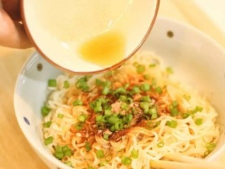 4、金城武泡面,然后我们捞出面条沥水之后，就迅速撒上麻油和葱花（泡面调料包也可以），迅速搅拌
