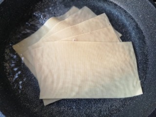 5、豆皮金针菇卷,将切成块的豆皮过开水焯一下去豆腥味，然后沥水捞出放凉备用。