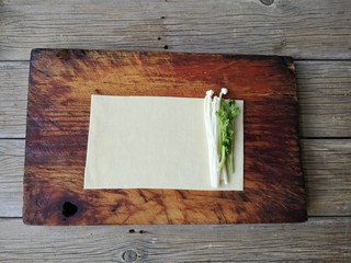 6、豆皮金针菇卷,将金针菇和香菜段放在焯过水的豆皮一侧。