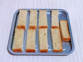 3、蒜香全麦吐司条,切好的全麦吐司条放入烤盘中。