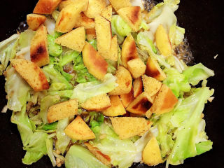 14、糖醋包菜,放入饼块儿翻炒均匀。