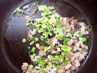 9、酱油蛋炒饭,倒入葱花煸香。