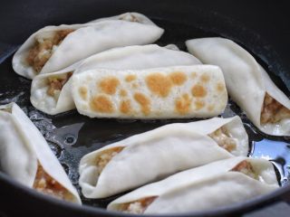 9、脆底猪肉洋葱锅贴,开小火煎至饼底呈焦黄色，淋入两汤匙清水盖上锅盖继续小火煎制