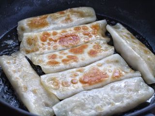 10、脆底猪肉洋葱锅贴,待锅内噼啪作响时将锅贴翻面，再淋入两汤匙清水，继续小火煎至水分蒸发干即可