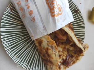 8、街头手抓饼的吃法----懒人必备早餐,卷起来放入纸袋中，懒人早餐就做好了。 