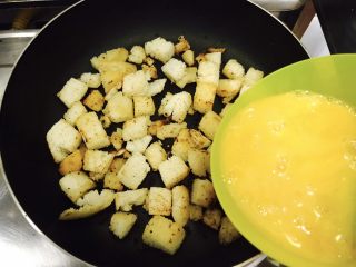 11、中西合璧的馒头鸡蛋披萨,中小火将馒头丁煎至金黄色，放入打好的鸡蛋液！