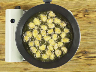 5、杏鲍菇秒变鸡米花,锅中倒油烧热，放入杏鲍菇，小火炸至色泽金黄，捞出沥油