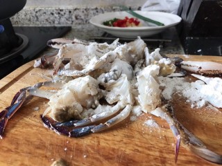 3、避风塘炒蟹,螃蟹取壳后清洗干净，挖掉腮，一只螃蟹可以切4～6块，根据螃蟹的大小定，用厨房纸巾擦干水份，撒上淀粉，少许盐，白胡椒调味(不用太多盐，蟹本来就很鲜美，裹粉的目的是让蟹肉在炸的过程当中保留水份，而且蟹黄不容易流失)