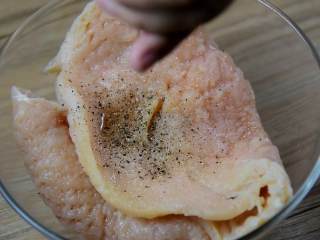 3、爆浆鸡排-慎点，看了会把持不住,锤好的鸡胸肉放入碗中，加入料酒2勺、盐1勺、黑胡椒少许，抓匀腌制30分钟。