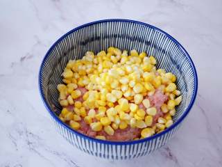 2、煎猪肉玉米饺子,把玉米粒洗净控干水分，和猪肉末一起放入容器中