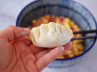8、煎猪肉玉米饺子,先对折再把上面的饺子皮往左一折一折那样折好捏紧压实