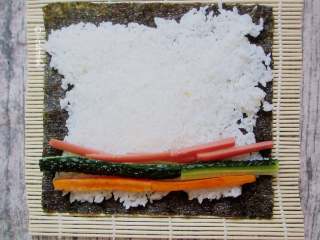 7、简易版寿司拼盘,把火腿肠、藕、黄瓜码上，放在下端三分之一处