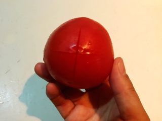 4、黑椒腊肠炒意面,在番茄上面切一个十字